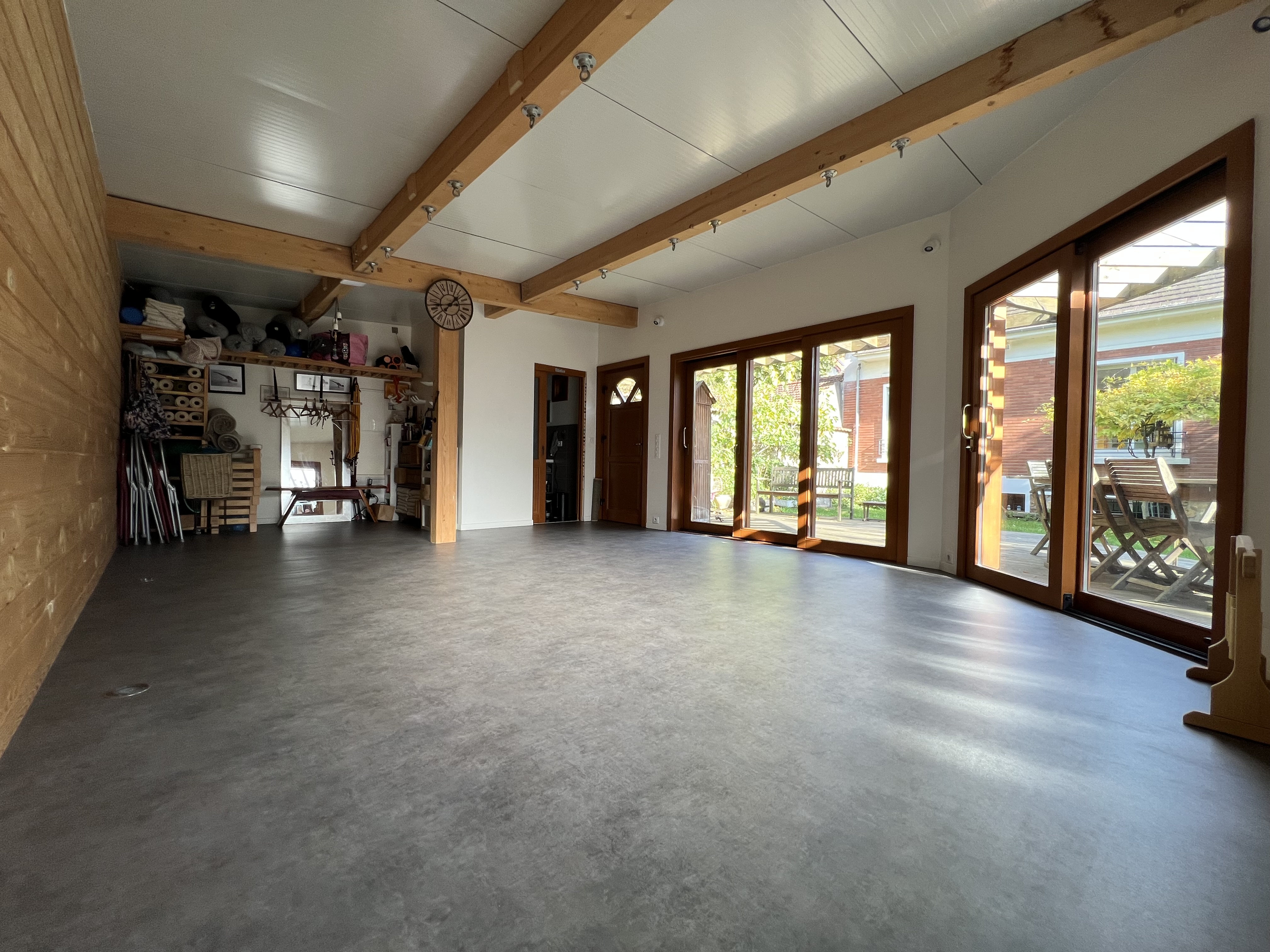 Salle de pratique avec vue sur vestiaires au fond et matériel