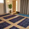 Salle de pratique de 32 m² avec parquet en chêne clair, baignée de lumière naturelle, prête pour un stage de yoga ou de méditation à l'Espace Ker Gana.