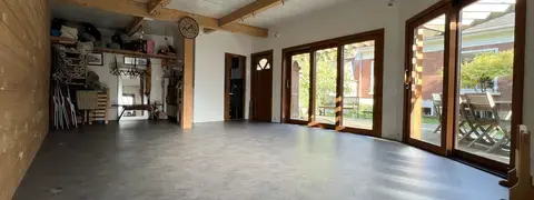 Salle de pratique avec vue sur vestiaires au fond et matériel