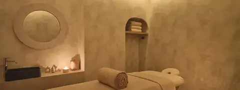 Salle de soins Sagesse — ambiance tamisée à la bougie, table de massage, OMVIDA